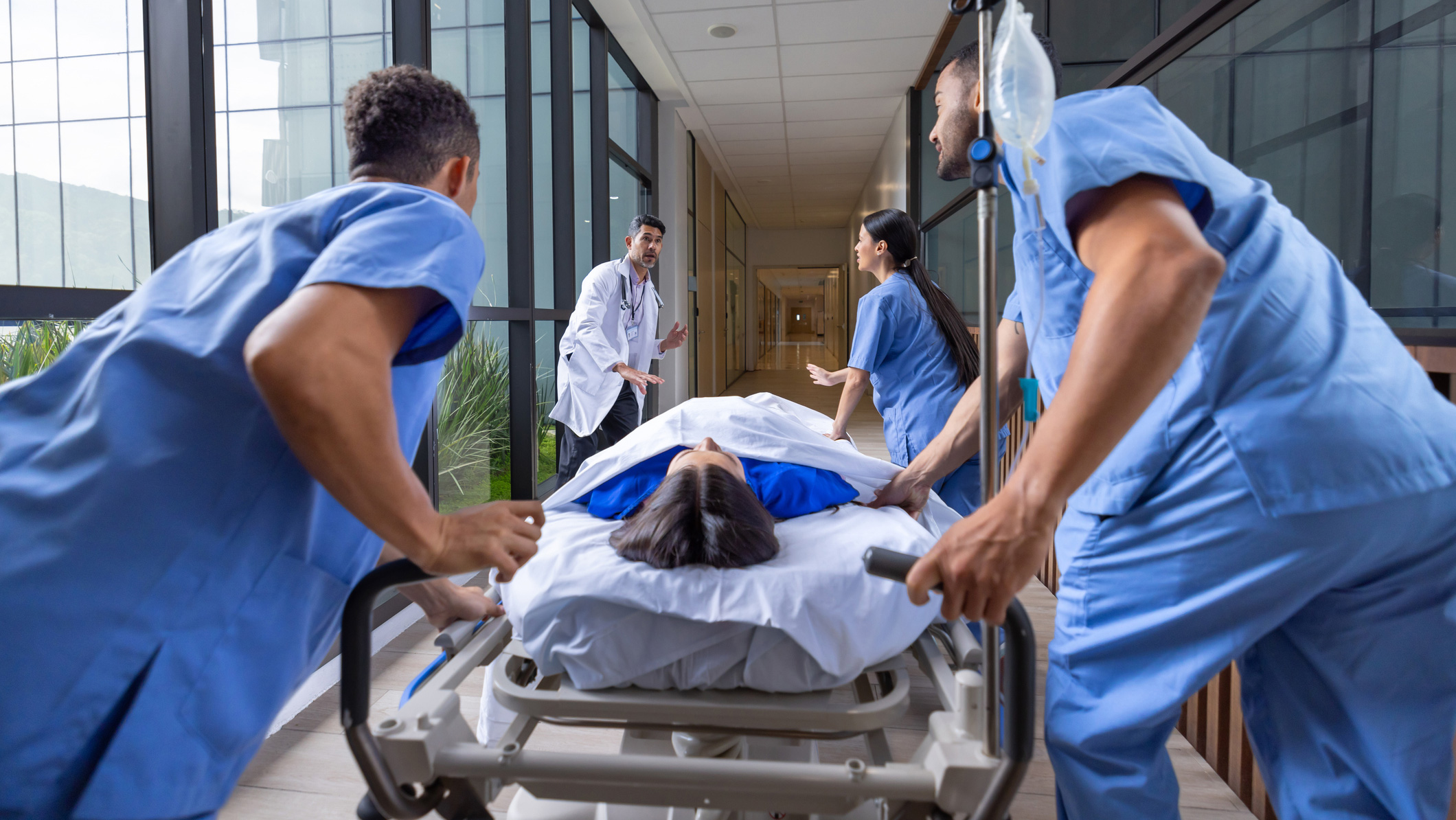 A patient being rushed into a building on a stretcher surrounded by medical staff. 