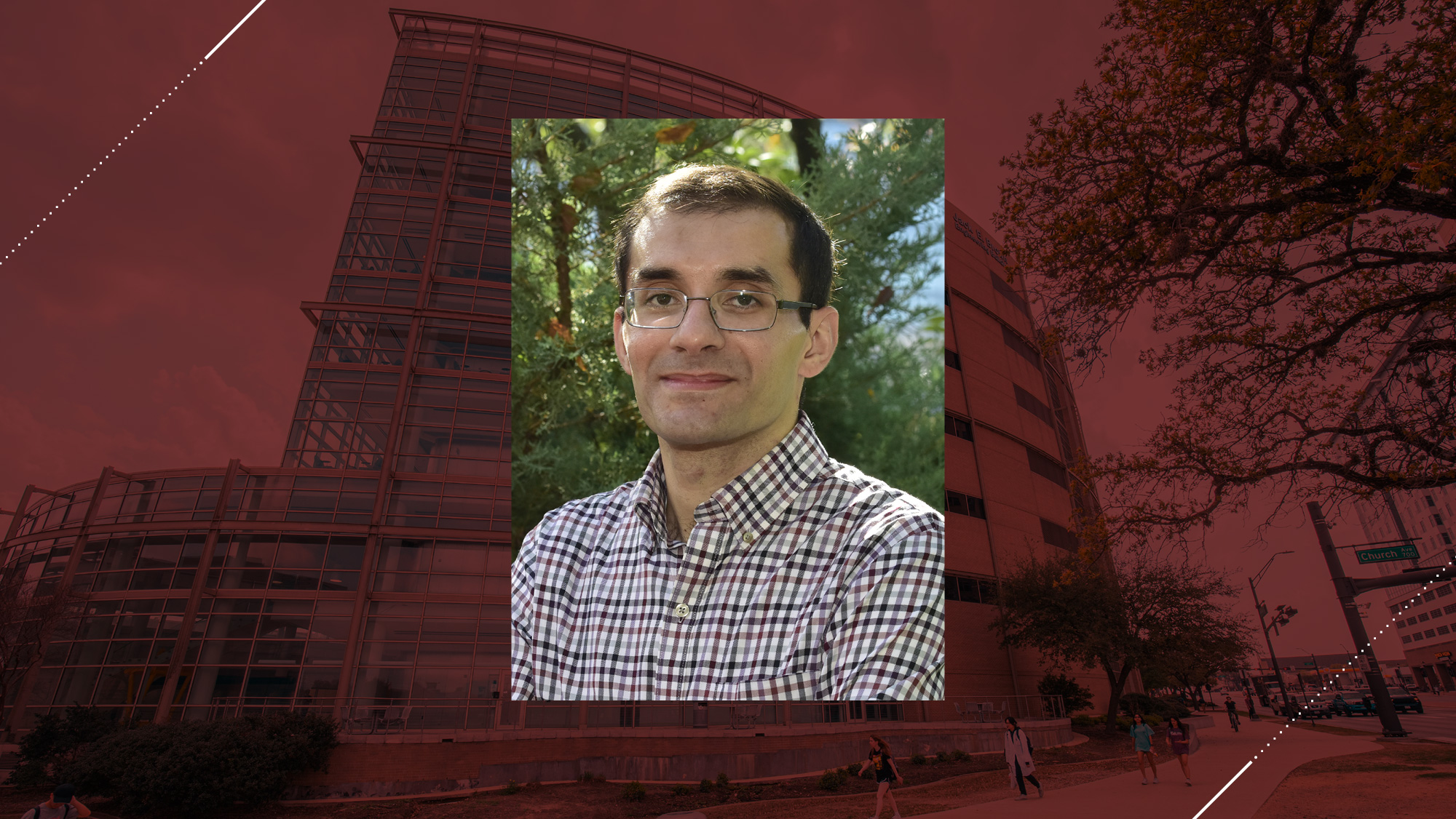 Headshot of a man on a maroon background.