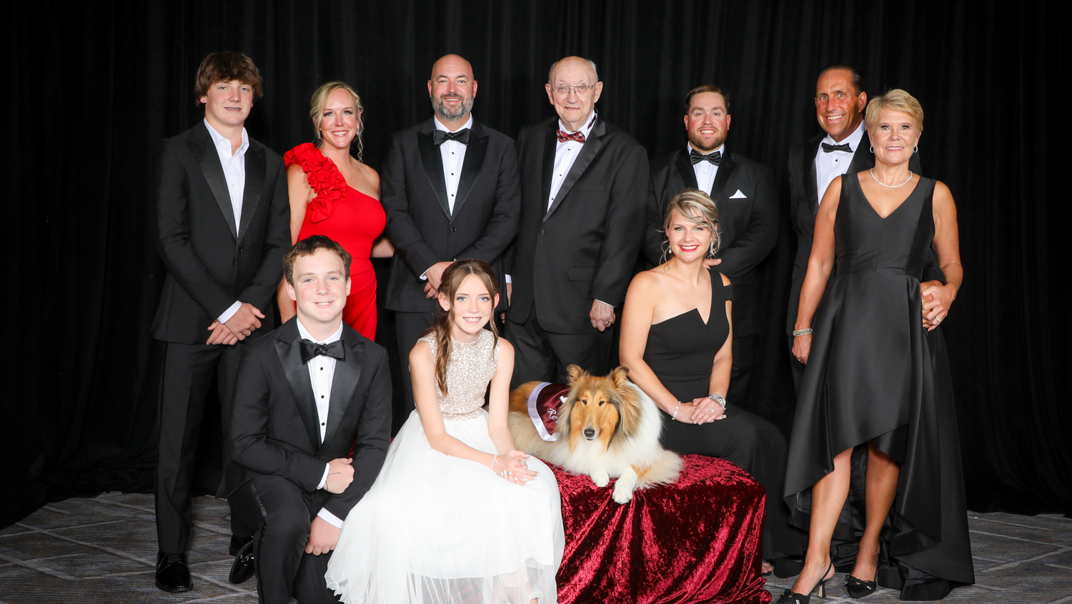 A group photo of a family with a dog.
