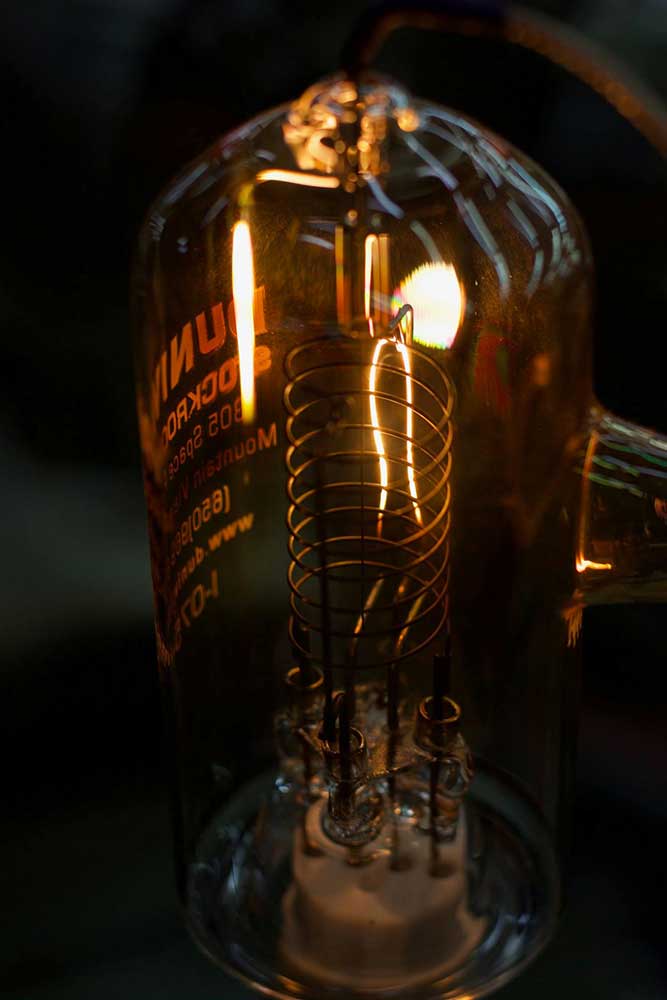 conical-shaped glass light bulb with spiral inner metal coiling and a lit wire element