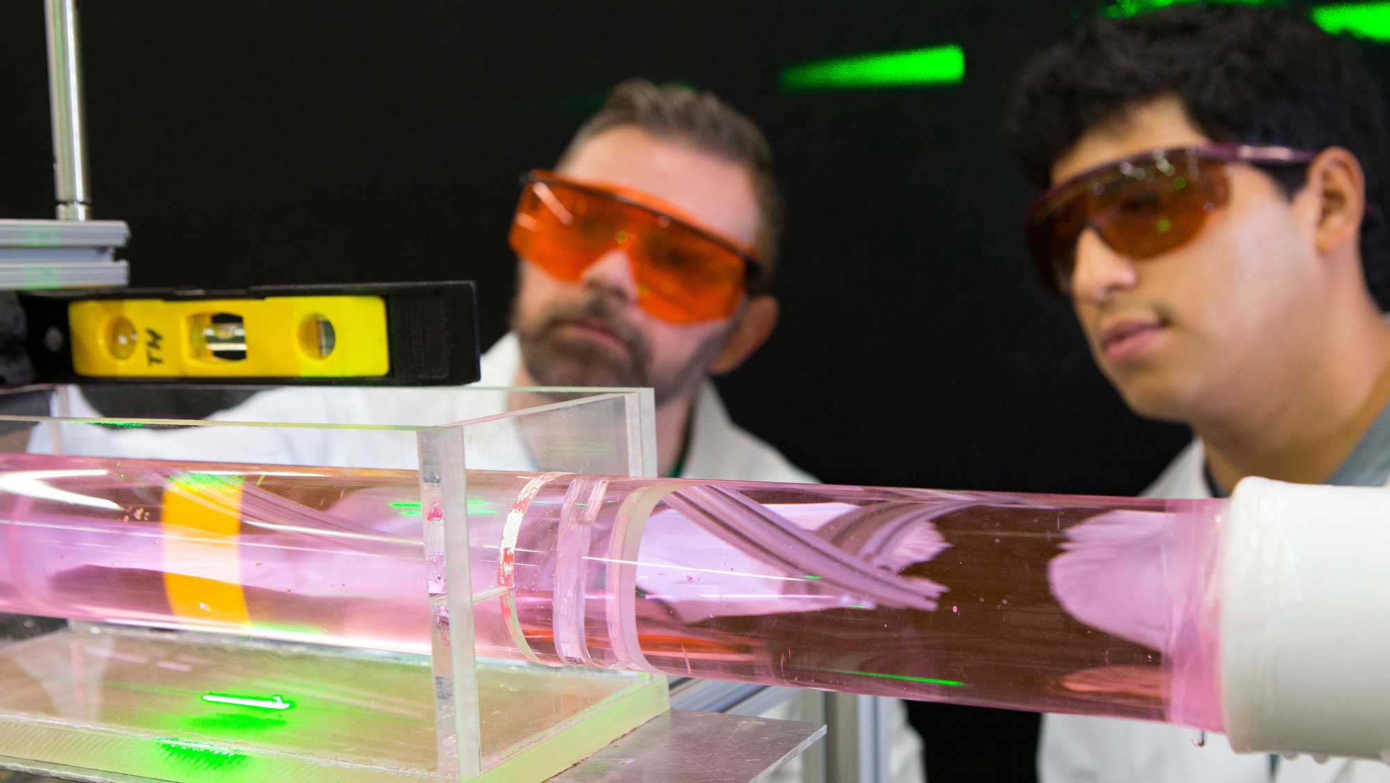 student and researcher examining a nuclear engineering experiment