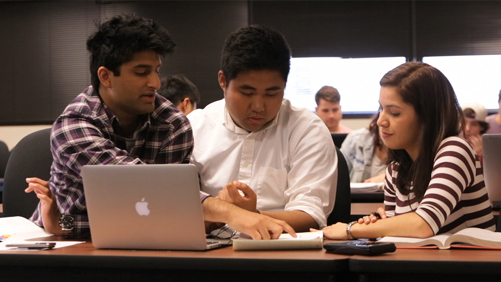 study group of three petroleum engineering students discussing course notes