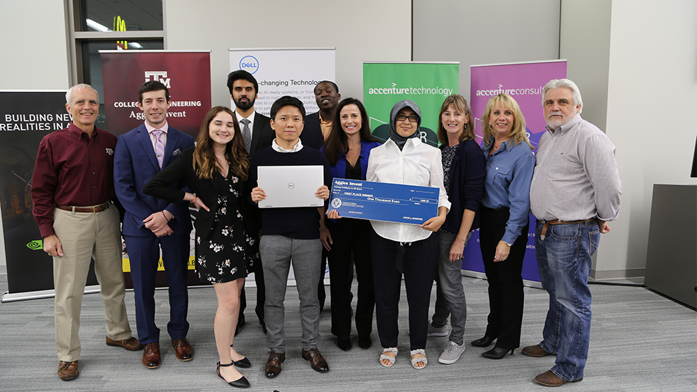 A group of students poses for a photo with people from industry