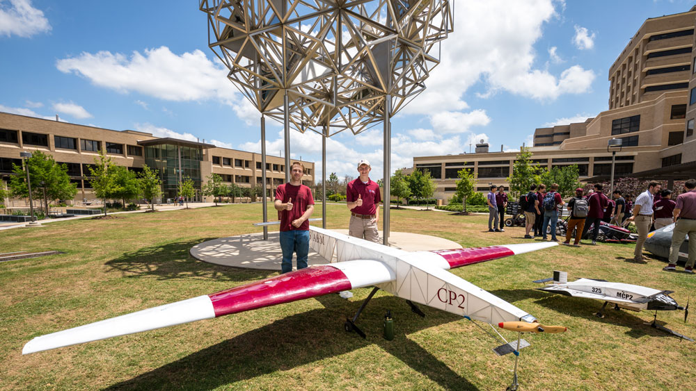 Two students with an airplane. 
